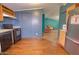 The kitchen showcases wood floors, essential appliances, and seamless access to the living space, enhancing the home's flow at 43384 W Padilla Rd, Maricopa, AZ 85138