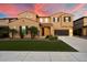 Inviting two-story home featuring a well-manicured lawn, lush palm trees, and an attached two-car garage at 5123 S Mariposa Dr, Gilbert, AZ 85298