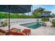 Backyard pool area provides a secluded retreat with mature trees, lush greenery, and blue patio umbrellas at 5438 E Lupine Ave, Scottsdale, AZ 85254