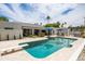 Relaxing backyard features a refreshing pool, covered patio, lounge chairs, and verdant landscaping at 5438 E Lupine Ave, Scottsdale, AZ 85254