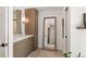 Bathroom with modern vanity, sconces, and a large framed mirror reflecting another bathroom at 5438 E Lupine Ave, Scottsdale, AZ 85254