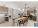 Bright open-concept dining area with modern light fixtures, a kitchen view, and stylish wood table and chairs at 5438 E Lupine Ave, Scottsdale, AZ 85254