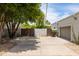 Wide driveway leading to garage with mature trees and desert landscaping at 5438 E Lupine Ave, Scottsdale, AZ 85254