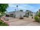 Home exterior showcasing driveway, garage, and desert landscaping, complemented by blooming flowers at 5438 E Lupine Ave, Scottsdale, AZ 85254