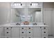 Elegant bathroom with double sinks, marble countertop, and decorative mirrors with modern lighting at 5926 E Hartford Ave, Scottsdale, AZ 85254
