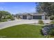 Attractive property featuring an extended driveway with a multi-car garage and well-maintained artificial turf at 5926 E Hartford Ave, Scottsdale, AZ 85254