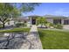 Beautiful home with lush landscaping, stone accents, and a welcoming walkway to the front door at 5926 E Hartford Ave, Scottsdale, AZ 85254