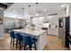Bright kitchen with marble island, counter seating, pendant lighting, and stainless steel appliances at 5926 E Hartford Ave, Scottsdale, AZ 85254