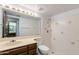 Bathroom featuring a tiled shower, white toilet, and a vanity with a light tan countertop at 6 E Manzanita Dr, Phoenix, AZ 85020