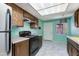 Kitchen featuring a white tile floor, turquoise walls, and black appliances at 6 E Manzanita Dr, Phoenix, AZ 85020