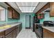 Kitchen with tiled floors, turquoise walls, and dark wooden cabinets at 6 E Manzanita Dr, Phoenix, AZ 85020