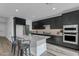 Kitchen featuring quartz island, stainless appliances, and modern black cabinetry at 6434 N 17Th St, Phoenix, AZ 85016