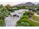 An elevated view of a luxury home with a large driveway and three car garage surrounded by trees at 6611 N 64Th Pl, Paradise Valley, AZ 85253