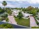Aerial view of the property featuring a circular driveway, well-manicured lawn, and lush landscaping at 6611 N 64Th Pl, Paradise Valley, AZ 85253
