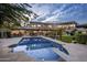Beautiful backyard oasis with a large pool, manicured lawn, covered patio, and elegant outdoor lighting at 6611 N 64Th Pl, Paradise Valley, AZ 85253