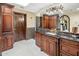 Luxurious bathroom with dark wood cabinets, granite counters, and a decorative mirror at 6611 N 64Th Pl, Paradise Valley, AZ 85253