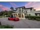 Stunning two-story home with a balcony and a beautiful red sports car in the driveway at 6611 N 64Th Pl, Paradise Valley, AZ 85253