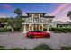 Beautiful two-story home with a black wrought iron balcony and a sporty red convertible in the driveway at 6611 N 64Th Pl, Paradise Valley, AZ 85253