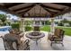 Inviting covered patio area with comfortable seating and a view of the fountain and manicured backyard at 6611 N 64Th Pl, Paradise Valley, AZ 85253