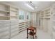 Well-organized walk-in closet with custom shelving and drawers and large arched windows at 6611 N 64Th Pl, Paradise Valley, AZ 85253