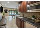 Wet bar with granite countertops, dark wood cabinets, mosaic tile backsplash, stainless steel under counter refrigerator at 6611 N 64Th Pl, Paradise Valley, AZ 85253