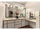 Main bath vanity area with double sinks, make up area and large mirror at 7604 N 46Th Ave, Glendale, AZ 85301