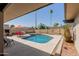 Backyard features a private pool, red patio set, built-in BBQ, and palm trees at 7604 N 46Th Ave, Glendale, AZ 85301