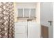 Laundry room with washer, dryer, overhead cabinets, and a patterned curtain for privacy at 7807 E Main St # Cc-71, Mesa, AZ 85207