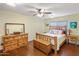Comfortable bedroom featuring wood floors, a ceiling fan, and a matching wood dresser and nightstand at 901 E Hearn Rd, Phoenix, AZ 85022