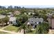 An aerial shot of the Tudor home set among lush trees and greenery with Phoenix skyline in background at 921 W Willetta St, Phoenix, AZ 85007
