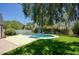 Beautiful backyard with a swimming pool, green grass, and mature trees at 921 W Willetta St, Phoenix, AZ 85007