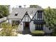 Charming Tudor-style home featuring a striking red door, black trim, and well-maintained landscaping at 921 W Willetta St, Phoenix, AZ 85007