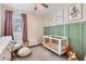 Bedroom features a crib, rocker, plush rug, and wall decor at 94 S 189Th Ln, Buckeye, AZ 85326