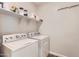 Functional laundry room featuring a washer, dryer, and storage shelves for supplies at 94 S 189Th Ln, Buckeye, AZ 85326