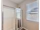 Shower with sliding glass door, white tiles, and a window for natural light at 94 S 189Th Ln, Buckeye, AZ 85326