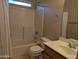 Bathroom featuring a shower-tub combo and tiled walls at 10399 E Hillery Dr, Scottsdale, AZ 85255
