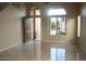 Spacious living room featuring tile flooring, arched windows, and an open entryway at 10399 E Hillery Dr, Scottsdale, AZ 85255