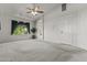 Spacious bedroom featuring a ceiling fan, large window with drapes and neutral carpet throughout at 1135 W Sea Fog Dr, Gilbert, AZ 85233