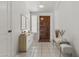 Bright foyer featuring tile flooring, white walls, and a wooden front door with adjacent furniture accents at 1135 W Sea Fog Dr, Gilbert, AZ 85233
