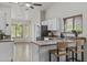 Bright kitchen featuring a breakfast bar with seating, tile floors, white cabinetry, and views to the dining area at 1135 W Sea Fog Dr, Gilbert, AZ 85233