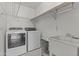 Functional laundry room features a washer, dryer, sink, and shelving for storage at 1135 W Sea Fog Dr, Gilbert, AZ 85233