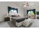 Serene main bedroom with a ceiling fan, plush bedding, and views of lush greenery outside at 1135 W Sea Fog Dr, Gilbert, AZ 85233