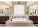Relaxing bathroom with a soaking tub, double vanity sinks, and decorative mosaic tiling, creating a spa-like experience at 13720 N 148Th Dr, Surprise, AZ 85379