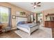 Spacious bedroom boasting wood-look floors, a ceiling fan, and easy access to the ensuite bathroom at 13720 N 148Th Dr, Surprise, AZ 85379