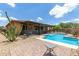 Backyard pool area with desert landscaping, shaded patio, and privacy fence, creating a relaxing outdoor space at 13720 N 148Th Dr, Surprise, AZ 85379