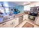 Modern kitchen featuring stainless steel appliances, white cabinets, and an island with bar stools at 16021 N 30Th St # 127, Phoenix, AZ 85032