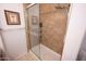 Close-up of a walk-in shower featuring decorative tile, glass door, built-in shelves and neutral colors at 16021 N 30Th St # 127, Phoenix, AZ 85032