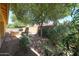 Landscaped backyard featuring gravel, trees, flowers, and an outdoor grill at 16528 W Lariat Ln, Surprise, AZ 85387