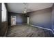 Gray bedroom features wood-look tile flooring, ceiling fan, and natural light at 16528 W Lariat Ln, Surprise, AZ 85387