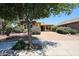 Charming single-story home with a brick driveway, manicured bushes, and stone accents at 16528 W Lariat Ln, Surprise, AZ 85387